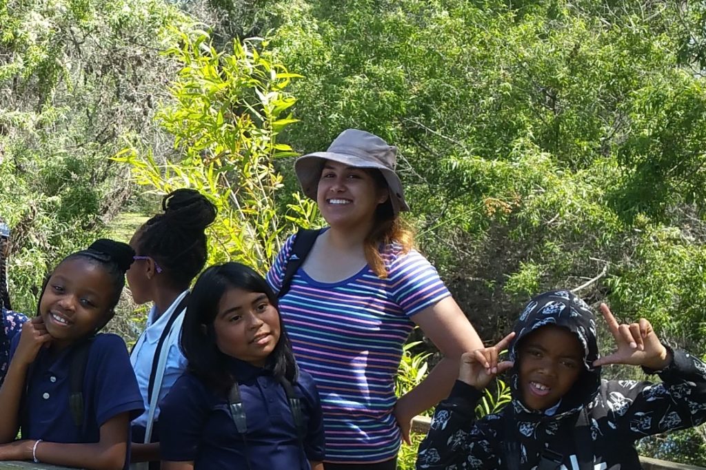 Sofia with a group of kids on a bridge at Madrona Marsh